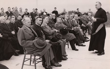 <p>Mgr Ferdinand Vandry, recteur de l'Université Laval, adresse la parole aux invités d'honneur au début de la cérémonie de bénédiction des terrains de la cité universitaire en septembre 1947. Maurice Duplessis était parmi les dignitaires invités.</p>