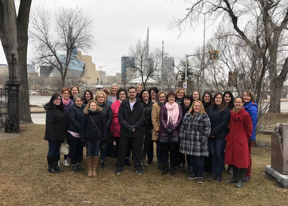<p>À Winnipeg, les participants de la formation sur la pratique de la philosophie avec les enfants prennent la pose sur l'emplacement de la cathédrale de Saint-Boniface, devant le Musée canadien pour les droits de la personne et le pont de l'Esplanade Riel.</p>