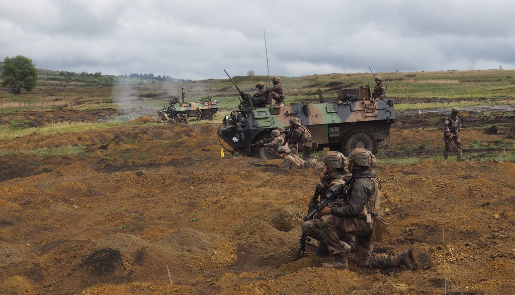 Des militaires français du 126e régiment d’infanterie, lors d’un exercice opérationnel multinational sur la base militaire de Cincu, en Roumanie, en avril 2022. Un véhicule de l’avant blindé est visible en arrière-plan.