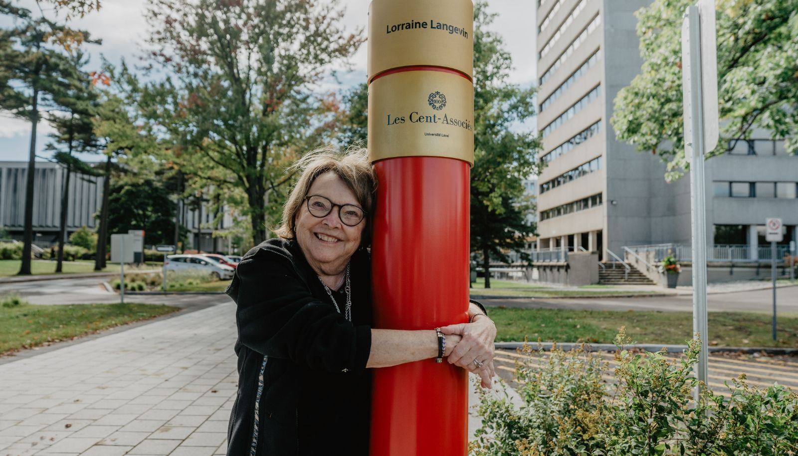 Lorraine Langevin posant avec le luminaire portant la demi-bague dorée à son nom sur la promenade des Cents-Associés.