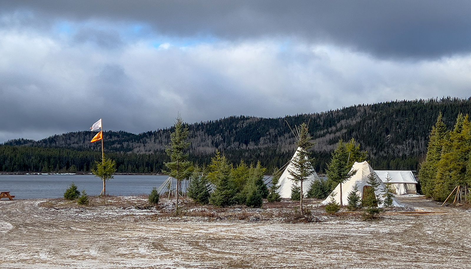 Des tentes et habitations traditionnelles, où ont dormi les visiteuses et visiteurs, sur le site traditionnel innu Kanapeut.