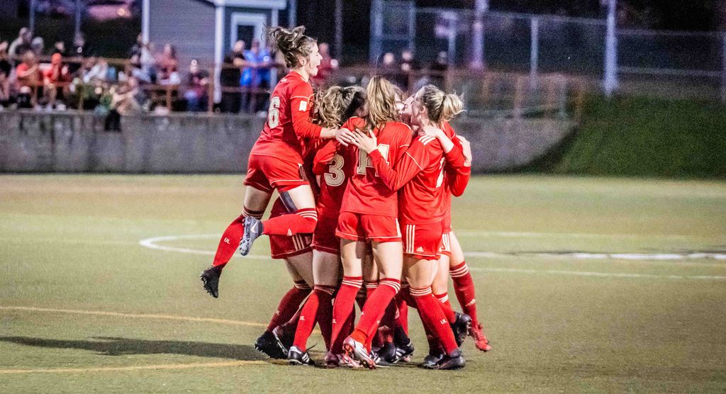 L'équipe féminine de soccer Rouge et Or célèbre après avoir marqué un but.