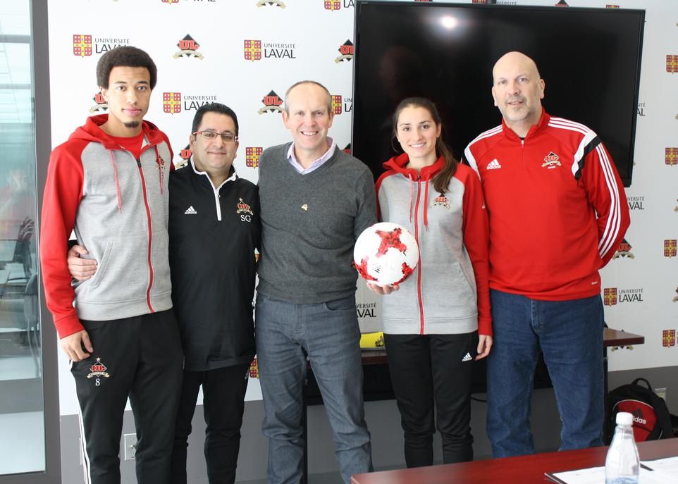 Les étudiants-athlètes Bila Dicko-Raynauld et Dominique Fortin ainsi que les entraîneurs Samir Ghrib et Helder Duarte entourent le nouveau président du conseil d'administration du Club de soccer Rouge et Or, Jean Martin.