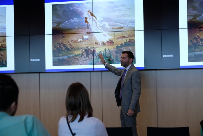 <p>Durant sa présentation, le consul général adjoint Michael Agner a utilisé plusieurs images pour illustrer son propos. Ici American Progress, une toile de John Gast réalisée en 1872 et représentant la conquête de l’Ouest américain. Une figure angélique guide les pionniers. Cette période de l’histoire des États-Unis fait partie de l’inconscient collectif et s’inscrit, de par sa dimension messianique, dans la religion civile de la culture politique de ce pays.</p>