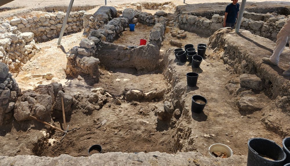 Une zone de fouilles du site Tel Azekah avec, au premier plan, deux pioches, une truelle et des seaux.