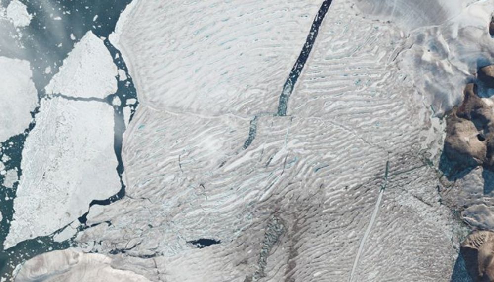 Image satellitaire de plateforme Milne peu de temps après sa rupture. À gauche, la partie qui s'est détachée, et qui s'est scindée en deux, a une superficie qui équivaut au sixième de l'île de Montréal.