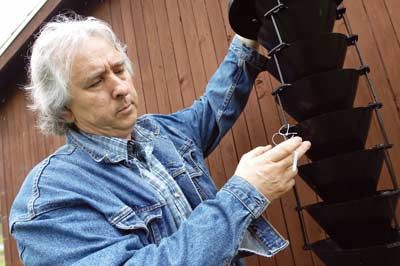 <p>Guy Bussières inspecte un des quatre pièges à scolytes installés sur le campus.</p>
