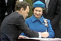 La cérémonie de signature, en 1982, sur la colline parlementaire d'Ottawa, de la proclamation visant le rapatriement de Londres de la constitution canadienne et sa révision subséquente. Le ministre de la Justice Jean Chrétien s'exécute face à la reine Elizabeth II.