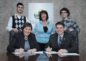 Les signataires de l'entente, Carole Voyzelle, pdg du Parc technologique du Québec métropolitain, et Guy Gendron, doyen de la Faculté des sciences et de génie. Derrière eux, Jean-Michel Dussault et Reno Lessard, étudiants en génie physique, entourent Isabelle Lapointe, de la firme Olympus.