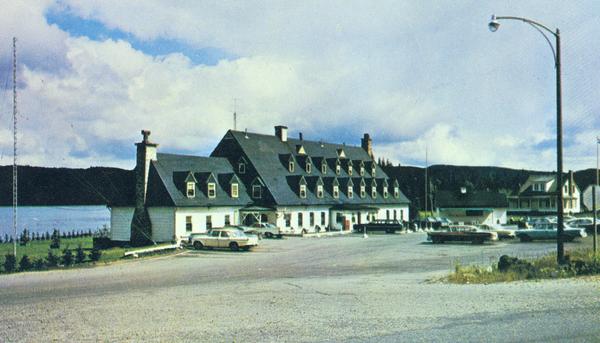 <p>L’Étape vers 1960. En 1950, la circulation automobile dans le parc des Laurentides atteint environ 120 000 voitures par an. À l’automne 1949, le gouvernement entreprend la construction d’un hôtel moderne sur les rives du lac Jacques-Cartier. Ce vaste édifice de style canadien s’étend sur 33,5 mètres de long et sur 13,4 mètres de large. En 1956, des travaux d’agrandissement ont lieu.</p>