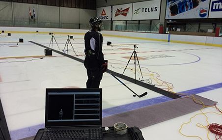 Le joueur de hockey se déplace sur une patinoire sur une distance d'environ 10 mètres à l'intérieur d’un corridor magnétique déterminé par une série de petits appareils de capture du mouvement posés sur des trépieds.