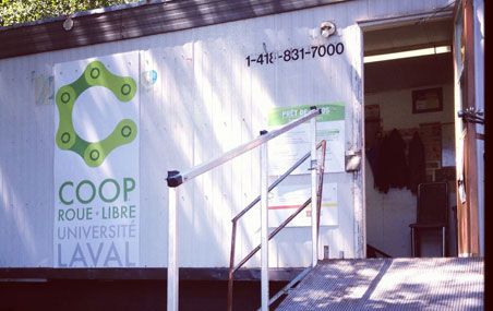 La Coop Roue-Libre de l'Université Laval est située dans une roulotte de chantier en bordure du stationnement devant le pavillon Alphonse-Desjardins.