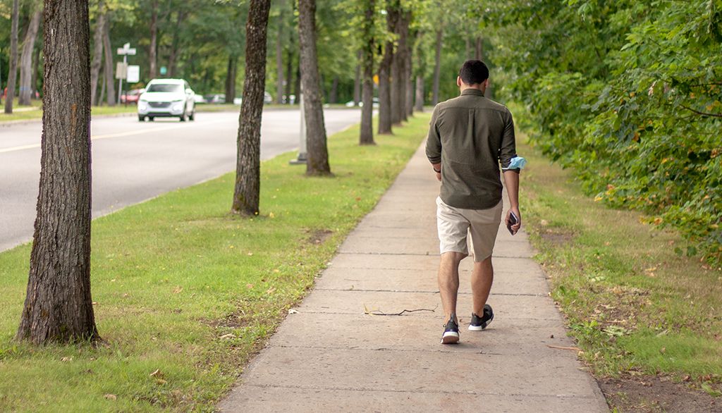 <p>Un étudiant marche sur la campus de l'Université Laval.</p>