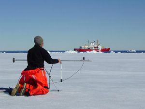 Un scientifique d'ArcticNet effectue des relevés à l'aide d'un radiomètre sur la banquise printannière de la Baie de Baffin.