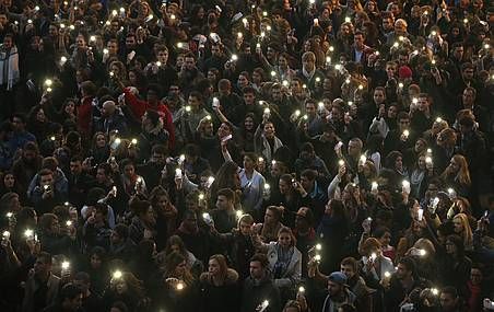 <p>Des personnes assemblées allument leur téléphone intelligent durant une vigile devant un mémorial sur la place du Capitole à Toulouse, le 17 novembre 2015.</p>