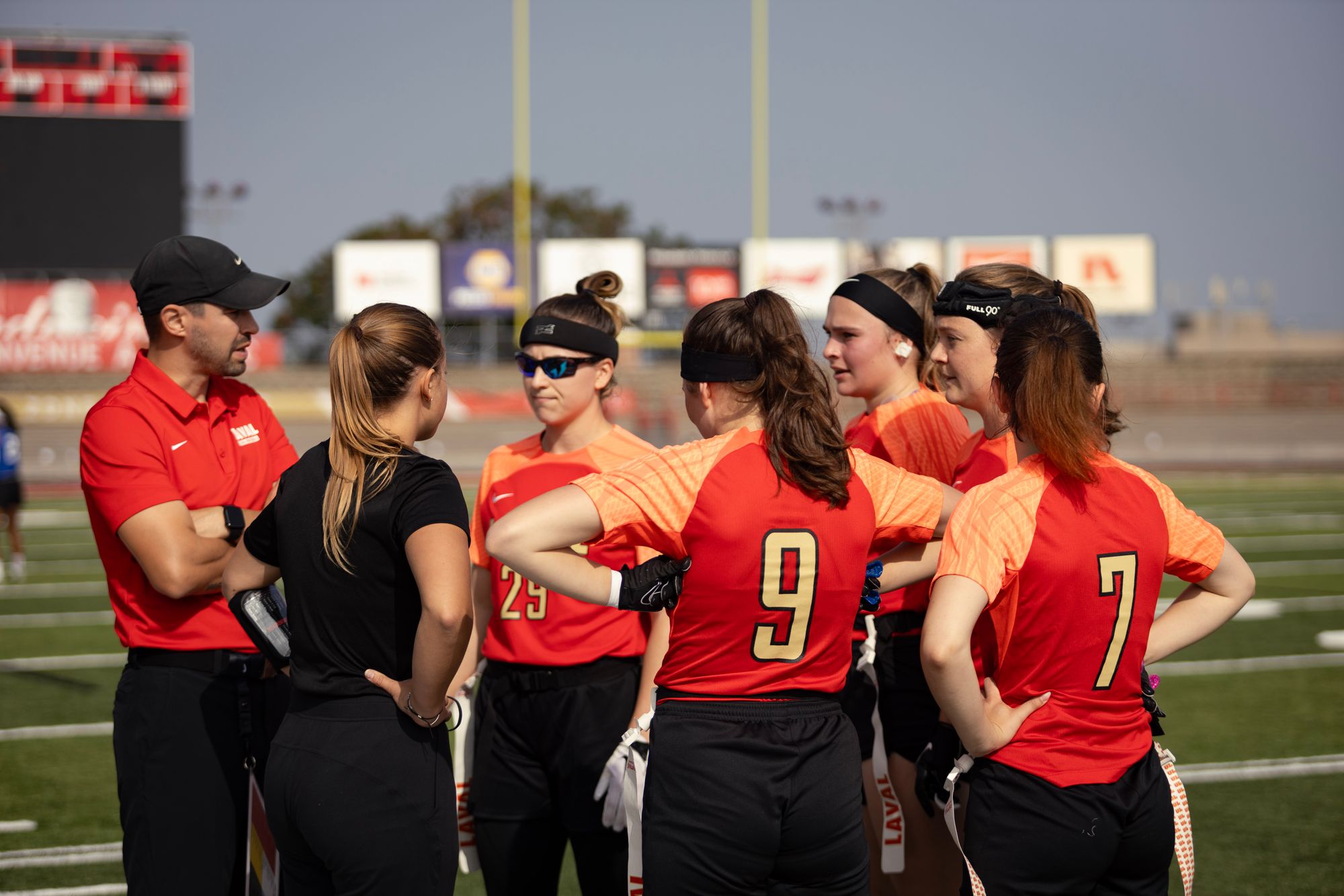 <p>L'entraîneur-chef de l'équipe de flag football de l'Université Laval, Jonathan Côté-Brassard, en compagnie de quelques joueuses de l'équipe.</p>