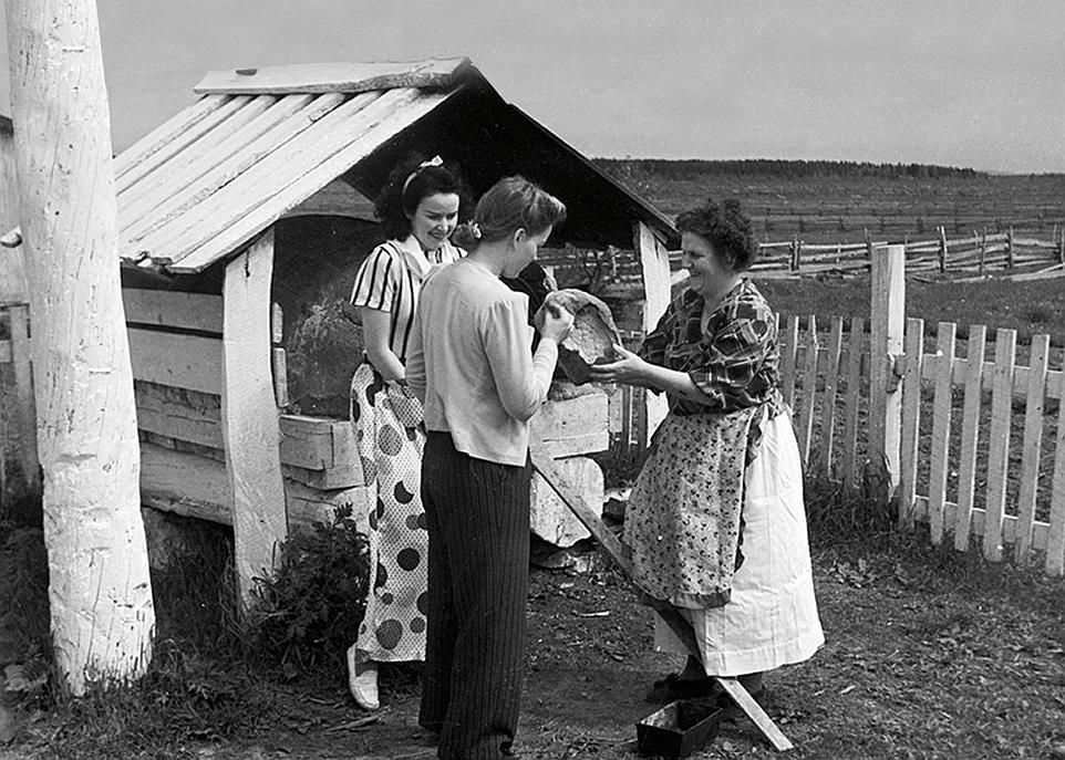 <p>En 1942, dans le village de Saint-Siméon, des femmes font cuire du pain à l'aide d'un four traditionnel.</p>