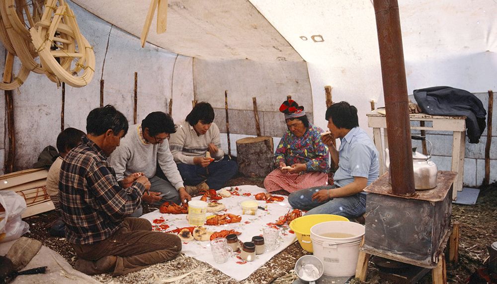 William-Mathieu Mark (à gauche), Hélène Mark et Philippe Mark (à droite) participent à un repas de homard sous la tente, en juin 1982, à La Romaine.