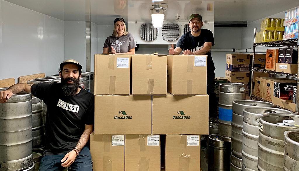 Dans le spacieux frigo à bière du Pub universitaire. Les grosses boîtes de carton contiennent les 1864 plats préparés pour Moisson Québec. Sur la photo: la directrice du Pub Marjorie Audet en compagnie du chef cuisinier Justin Tanguay, à gauche, et du gérant Gabriel Harvey.