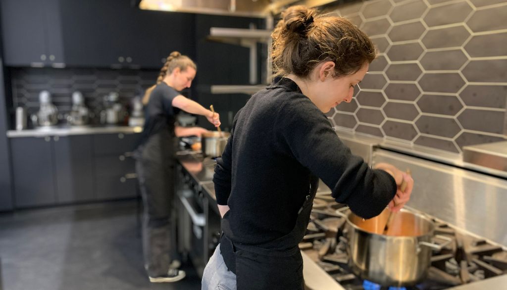<p>Deux étudiantes préparent un potage crémeux aux lentilles de corail dans les cuisines de l'INAF.</p>