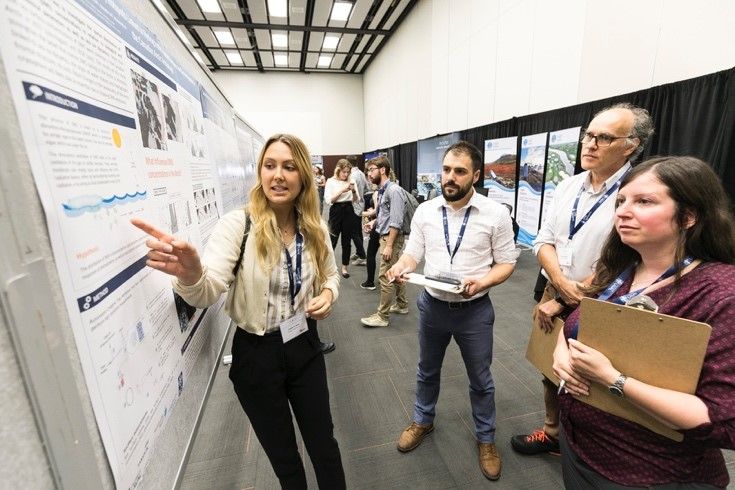 L'étudiante à la maîtrise en biologie Joanie St-Onge présente ses résultats de recherche devant trois évaluateurs du concours d’affiches scientifiques : Marc-André Ducharme, coordonnateur scientifique d'ArcticNet, Denis Boudreau, professeur au Département de chimie de l'Université Laval, et Caroline Ménard, professeure au Département de psychiatrie et de neurosciences de l'Université Laval.