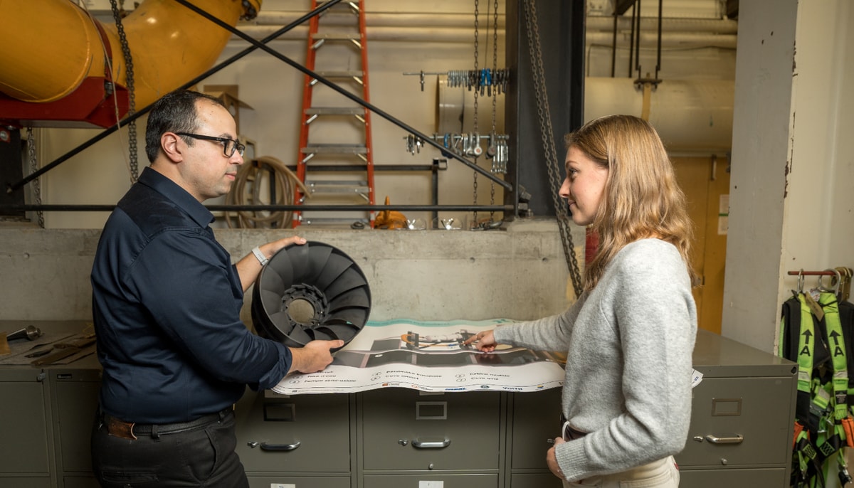 L'étudiant Araz Rezavand Hesari et l'étudiante Axelle Cara discutent de l'instrumentation d'un modèle de turbine Francis.