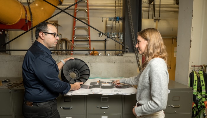L'étudiant Araz Rezavand Hesari et l'étudiante Axelle Cara discutent de l'instrumentation d'un modèle de turbine Francis.