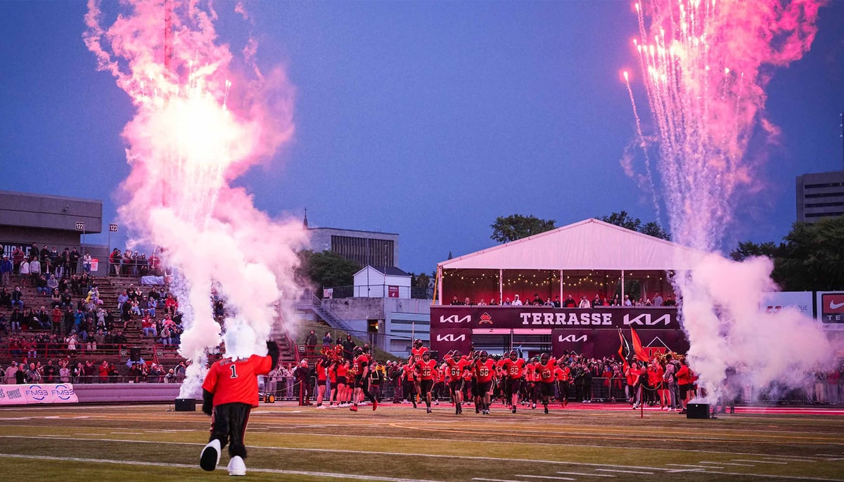 Les joueurs du club de football Rouge et Or de l'Université Laval font leur entrée sur le terrain lors de leur match inaugural le 5 septembre 2026, contre les Stingers de l'Université Concordia.