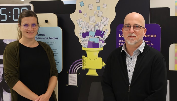 Julie Goulet-Kennedy, coordonnatrice de l'exposition, et Philip Jackson, directeur scientifique de la recherche de l'OBVIA, devant le module consacré aux systèmes générateurs de textes assistés de l'IA.