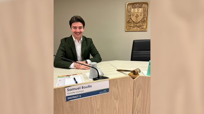Samuel Boutin, tout sourire, siégeant à la table du conseil municipal de Beauceville.