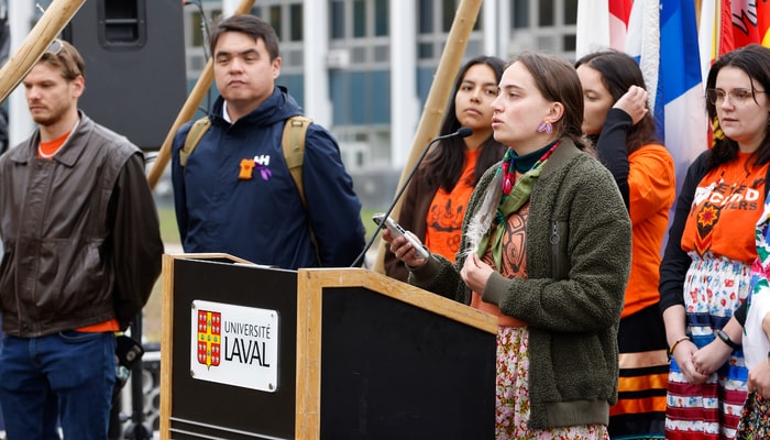 Au micro, Maïthé Boivin, membre de la Première Nation Wolastoqiyik, inscrite à la maîtrise en anthropologie et coprésidente de l'Association des étudiants autochtones de l'Université Laval