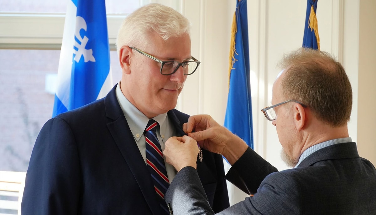 Yan Cimon reçoit l'insigne de chevalier de l'Ordre des Palmes académiques des mains d'Éric Lamouroux, consul général de France à Québec.