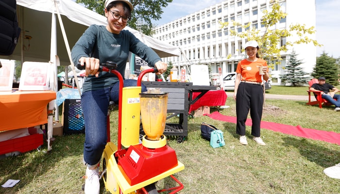 Une utilisatrice du vélo smoothie. Celui-ci sera à la disposition de celles et ceux qui voudront produire l'électricité nécessaire au fonctionnement d'un mélangeur.