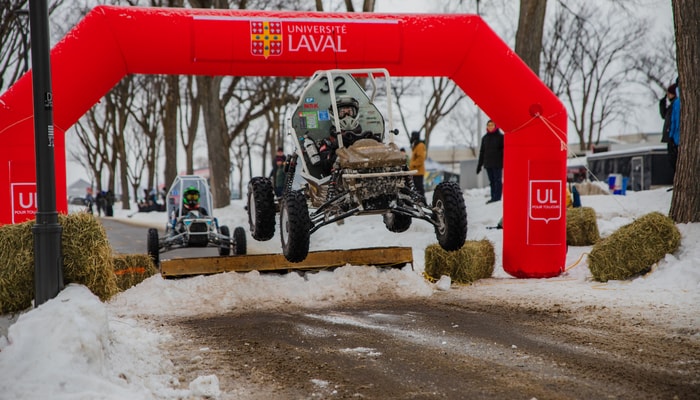 Dans le cadre de cette compétition d'ingénierie, les étudiantes et les étudiants doivent concevoir des véhicules tout-terrain robustes capables de franchir des terrains accidentés. On les voit ici à l'œuvre.