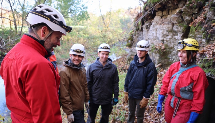 À l'extérieur de la grotte, l'attente se charge d'un mélange de tension et d'excitation.