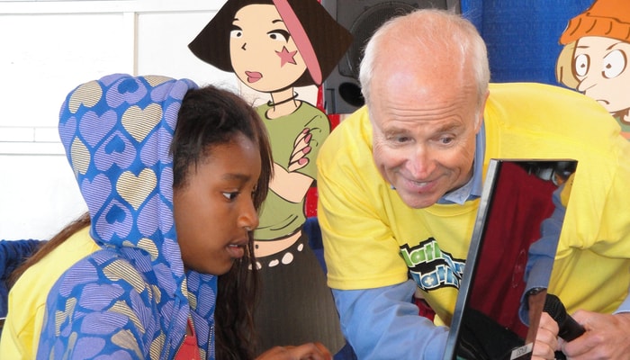 Le professeur Jean-Marie De Koninck avec une enfant qui joue au jeu en ligne Math en jeu.