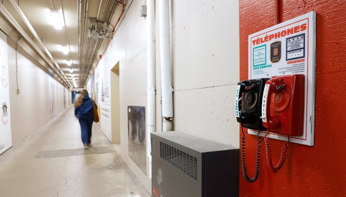 Parmi les changements réalisés dans les tunnels de l'Université Laval, une large bande rouge a été peinte au mur et au sol autour de chaque téléphone d'urgence pour rendre plus visible la présence de l'appareil. 