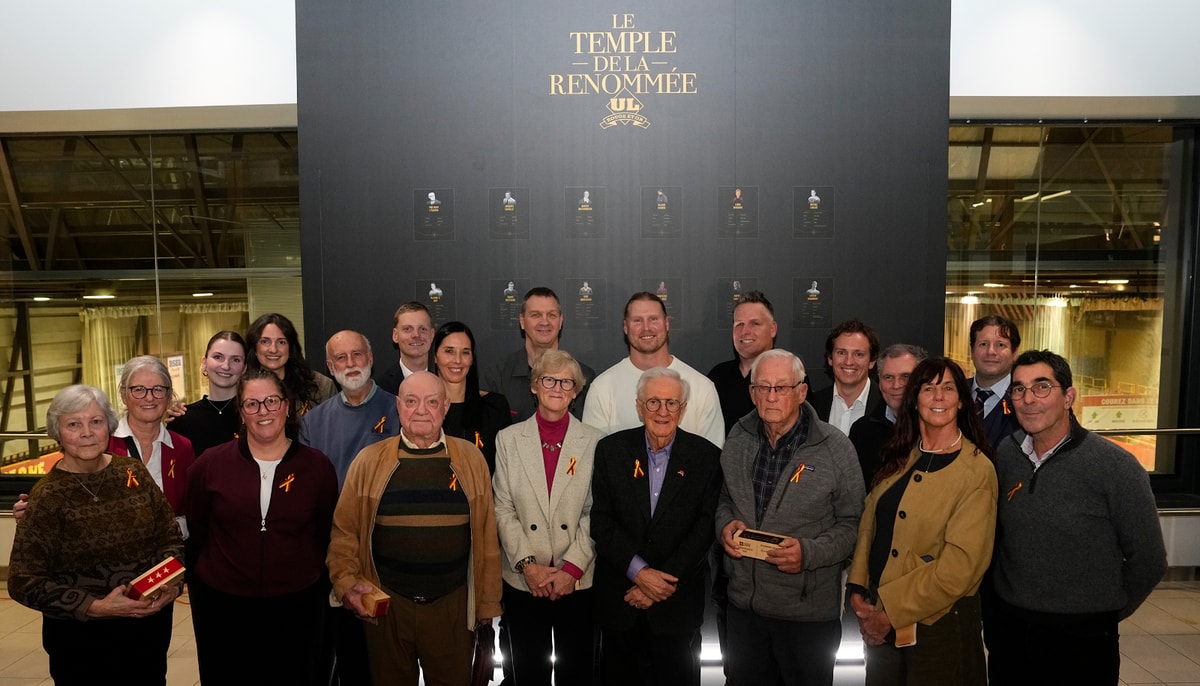 Les personnes intronisées au Temple de la renommée du Rouge et Or devant le mur commémoratif qui porte leurs noms, lors de la cérémonie du mercredi 10 décembre