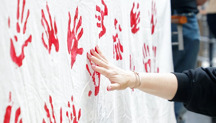 Des participantes et participants au rassemblement ont laissé leur empreinte sur un drap blanc, en signe de solidarité.