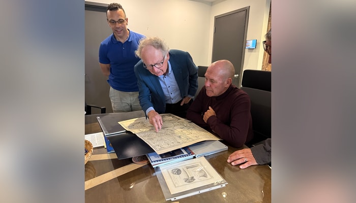 Simon Langlois (au centre) et le grand chef Picard (à droite) analysent la toponomie autochtone sur une carte de Vaugondy (1755). Ils sont accompagnés de l'archiviste Raphael Boney (à gauche).