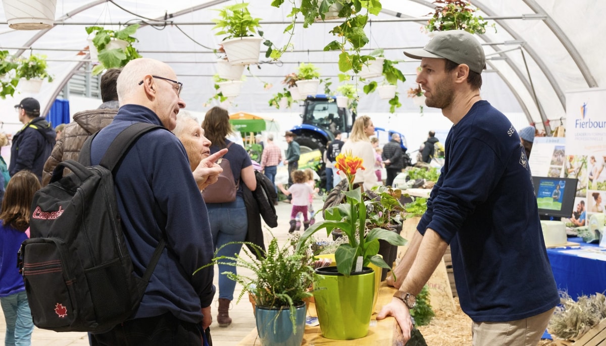 Un couple de visiteurs en discussion dans la section jardin du salon de la SAAC 2025