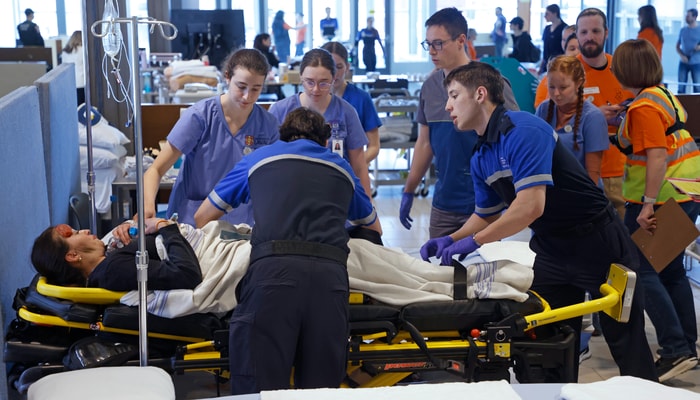 Des étudiants et étudiants interviennent auprès d'une personne simulant une blessure lors de l'événement Code Orange 2025.