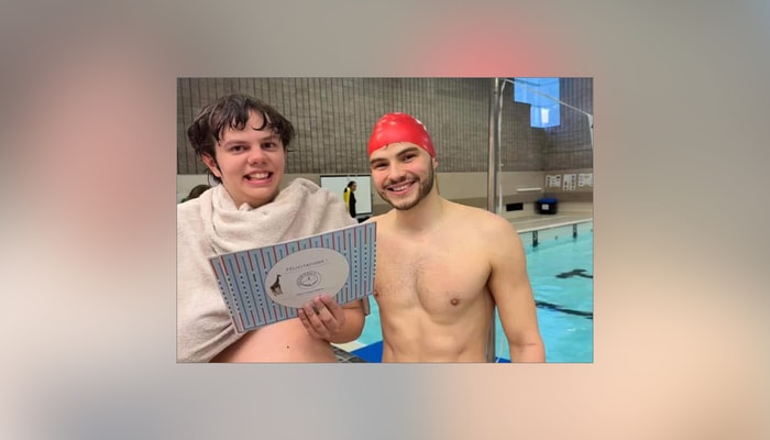 Vincent Lavoie-Rancourt remet un diplôme à son élève pour souligner sa réussite et sa persévérance après avoir terminé sa session complète de cours de natation adaptés avec BALEIN'eau.