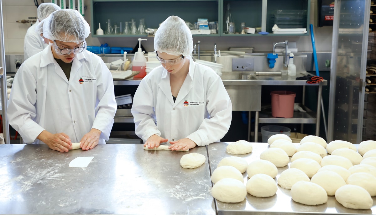 Deux membres de la Fromagerie du campus, Victor Lalancette et Alysson Guimont, aident le comité de la Boulangerie du Comtois à préparer plusieurs kilos de pâtes pour les pains à hot dog servis à l'Oktoberfest.