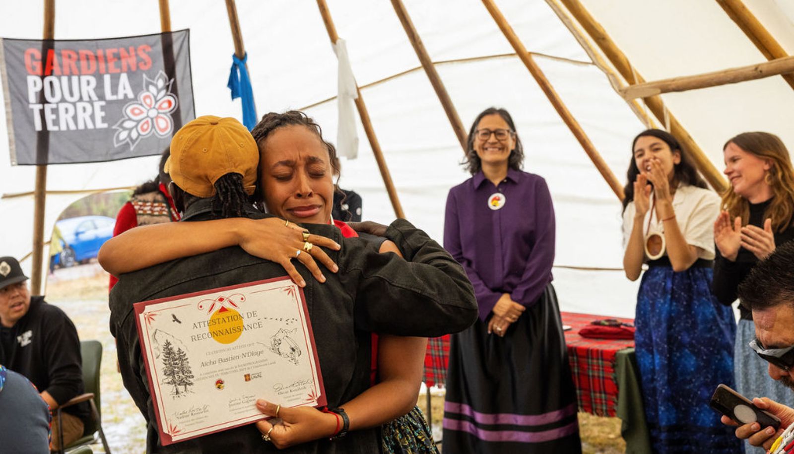 Aïcha Bastien N'Diaye, Wendat et gardienne diplômée, serre ici son père dans ses bras. On aperçoit aussi Michèle Audette, conseillère principale à la réconciliation et à l'éducation des Premiers Peuples à l'Université Laval, Marie-Philippe Ménard, coordonnatrice du nanoprogramme, et Justine Gagnon, professeure responsable.