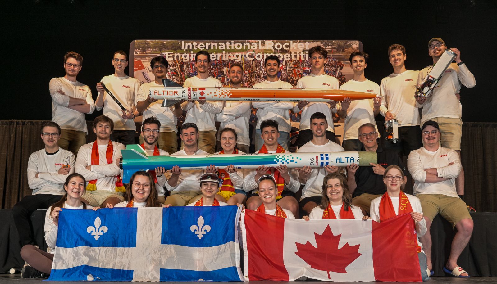 L'imposante délégation du GAUL à l'International Rocket Engineering Competition. Au deuxième rang, des étudiants et une étudiante tiennent dans leurs mains le premier étage de la fusée. D'autres étudiants, au troisième rang, font de même avec le second étage.