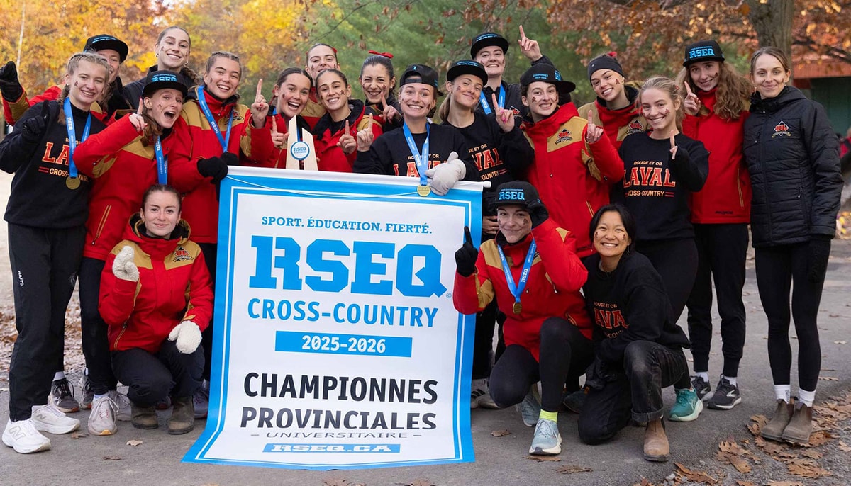 Les membres de l'équipe féminine de cross-country Rouge et Or de l'Université Laval posent avec leur bannière du championnat provincial 2025-2026.