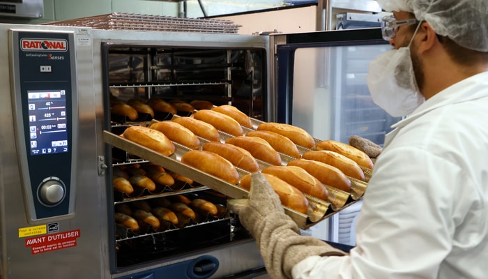 Adam Duquette, président du comité, sort les pains à hot dog du four.