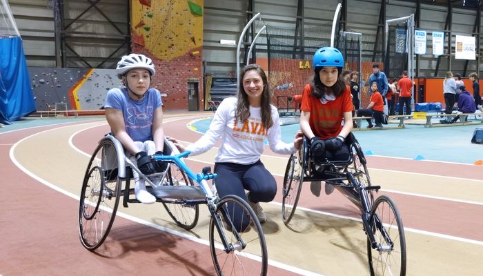 Il y a un an, les deux jeunes para-athlètes Édouard et Annabelle ont pris la pose en compagnie de leur entraîneuse Camille Rheault, sur la piste d'athlétisme intérieure du PEPS de l'Université Laval. Édouard faisait de la course en fauteuil, sport qu'il a remplacé depuis par les lancers du poids et du javelot.