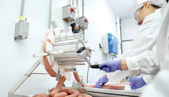 Les saucisses sont coupées à l'aide d'une machine, ce qui permet au comité de gagner du temps.